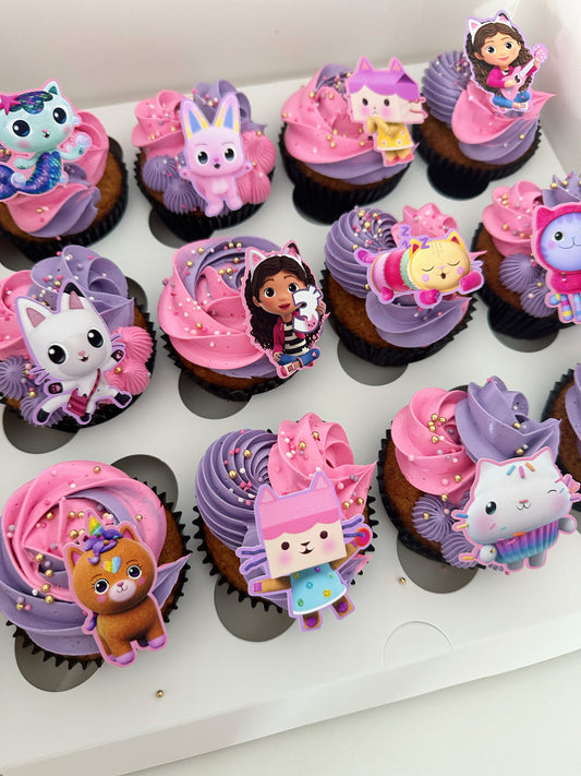 Gabbys Dollhouse cupcakes with pink and purple buttercream, sprinkles, and characters